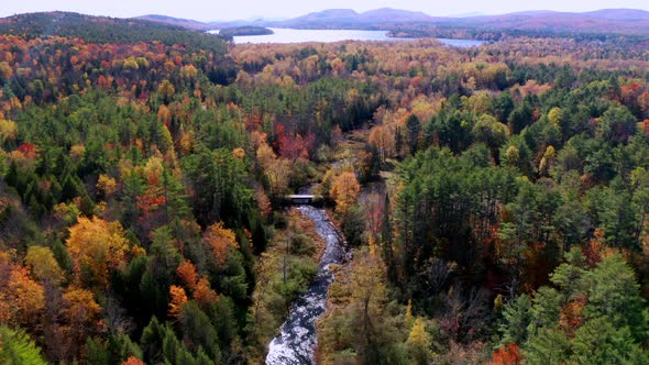 Aerial flythrough of Winding River Through Autumn Trees with Fall Colors in New England