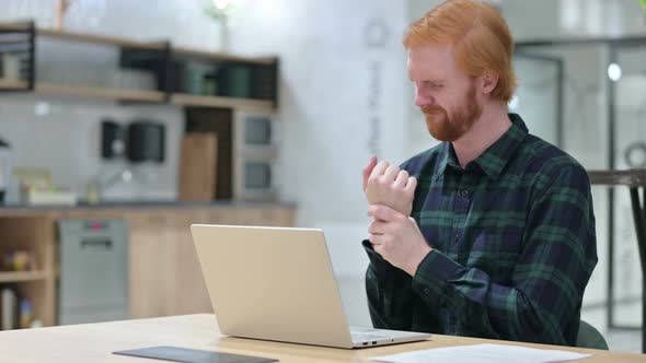 Beard Redhead Man with Laptop in Cafe Having Wrist Pain  alt