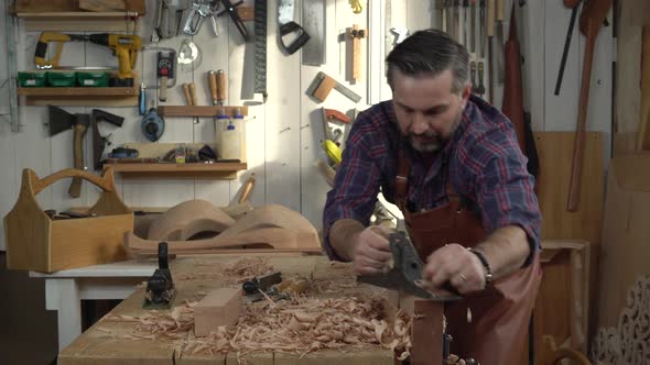 Cabinetmaker Planes Solid Wood in his Workshop alt