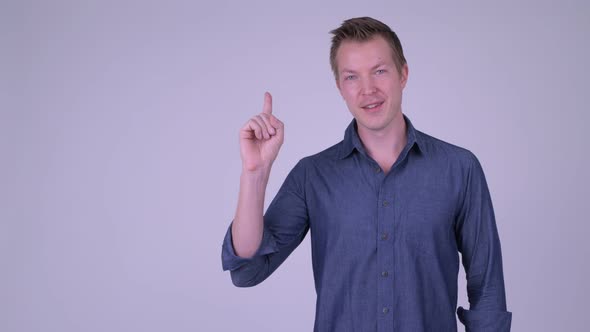 Portrait of Happy Young Handsome Businessman Showing Something alt