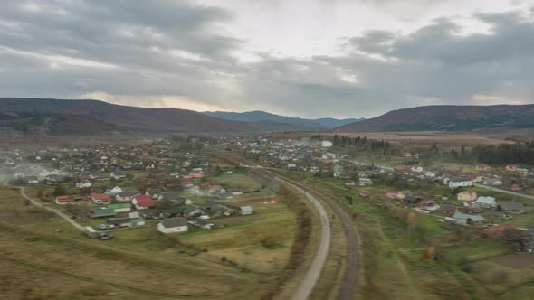 Aerial Timelapse of a Village in the Autumn Carpathian Mountains Covered with Spruce Forests Under a alt