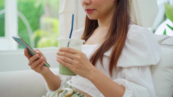 Young woman with drinks using mobile phone and relaxing in cafe, Modern lifestyle