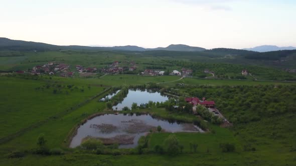 Aerial view of the valley around Colibita Lake in Romania with drone flying forward. Clip starts wit alt