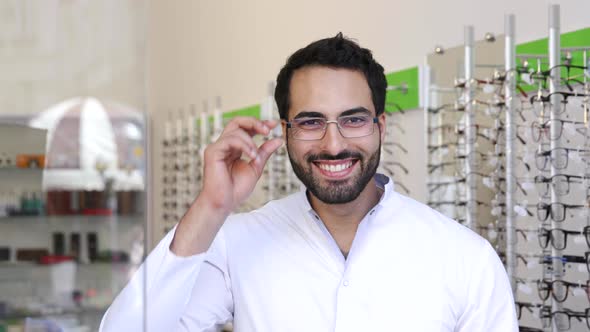 Optician Doctor Near Showcase With Eyeglasses At Glasses Shop