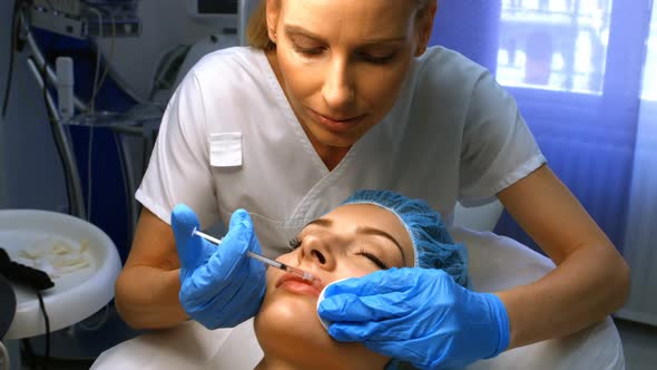 Doctor inserting facial injection on female patient lips alt