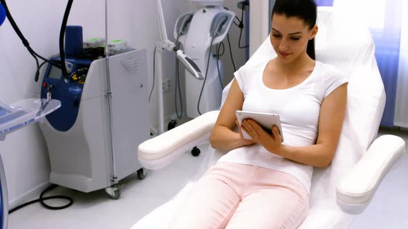 Female patient using digital tablet in clinic alt