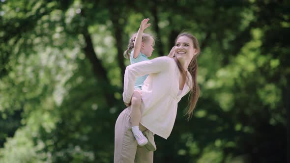 Family Fun. Mother And Daughter Playing And Laughing In Park alt