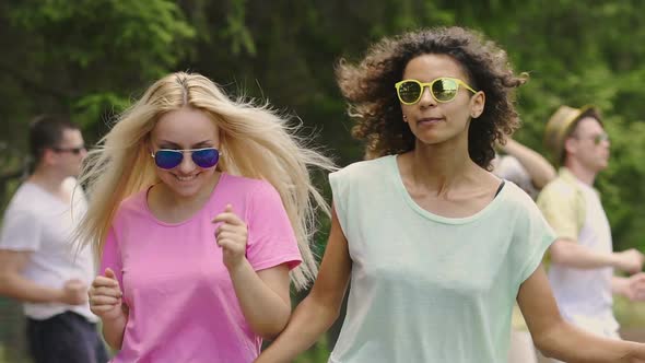 Blonde and Brunette Girls Dancing, Hanging Out at Concert in Park, Happiness alt