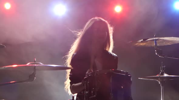 Drummer Professionally Plays a Musical Instrument, Black Smoke Background. Red Blue Light From alt