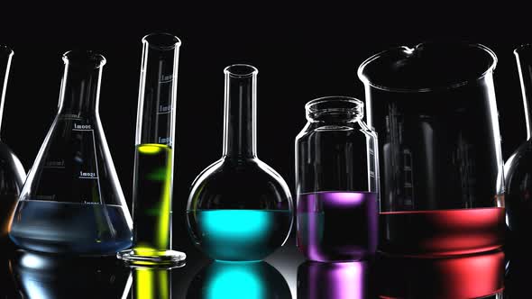 Laboratory glassware with colorful liquids inside on a black background looping. alt