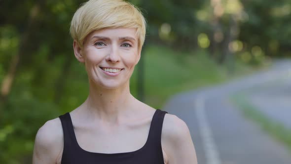 Portrait Outdoors Caucasian Middle Age Female Trainer Sportswoman Slim Woman in Black Sportswear alt