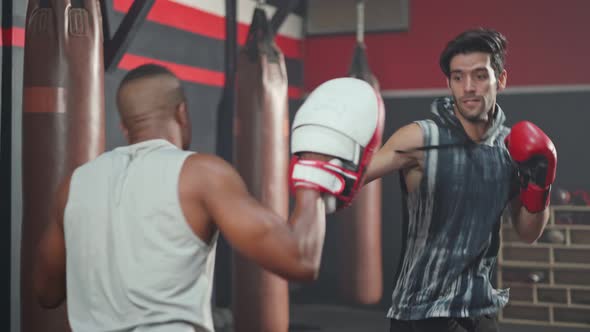 Active African Fitness trainer guy teach sportsman workout exercise doing boxing or Muay Thai in gym alt