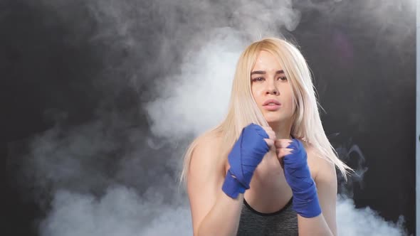 Attractive Blonde Sportswoman in Kickboxing Bandages in Defensive Stance, Slow Motion alt