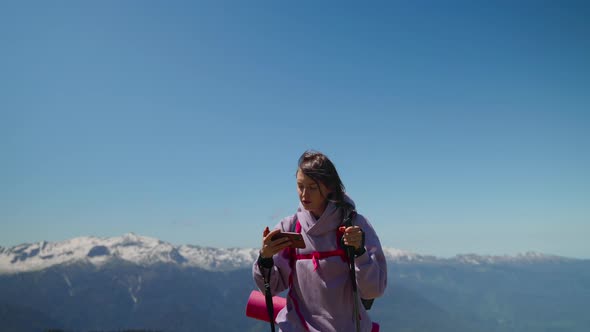 Tourist Woman is Orienting By Electronic Map in Mobile Phone in Mountains alt