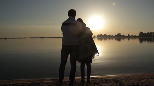 Man and Woman Standing Near the Sea Shore at Dawn alt