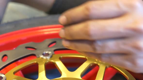 Close-up Footage of Mechanic Working On Disc Brake Installation For Motorcycle alt