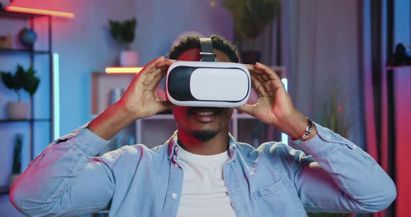 Guy Putting on Virtual Reality Headset and Starting to Work on Imaginary Display in Home Office alt