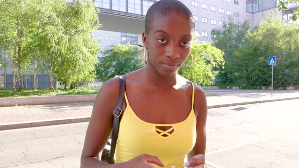 Young woman using smartphone in city alt