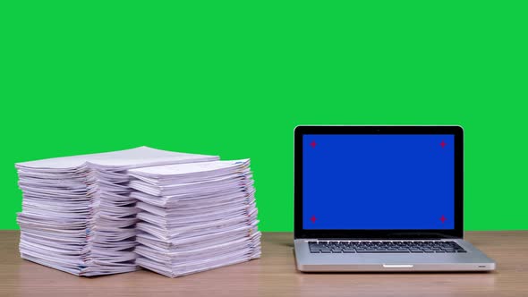 Stop motion animation Stacks overload document paper files and Blue screen laptop computer