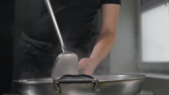 Chef Tosses Fried Vegetables with Noodles in Hot Wok in Slow Motion, Cooking Asian Noodles, Stirring alt