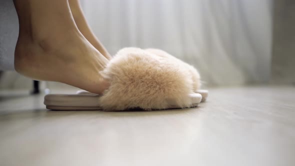 female feet get out of bed put on shaggy pink slippers and go away