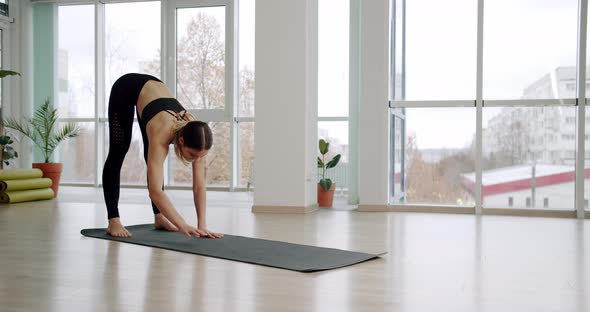 Athletic Girl Gets Up on the Yoga Mat After the Exercise Done to the End alt