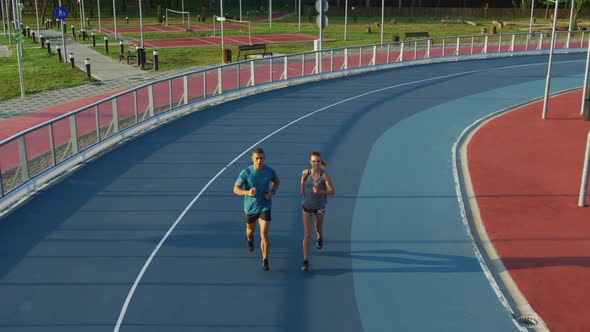 Young couple running on a track alt