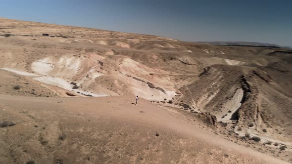 Aerial View of a Man Walking Forward in the Desert Alone