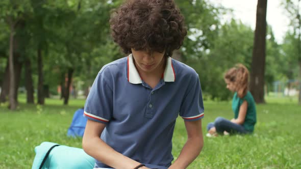 Teenage Boy with Laptop Outdoors alt