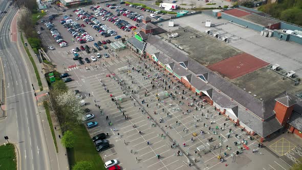 People in the UK queuing following social distancing rules to go inside the Asda supermarket