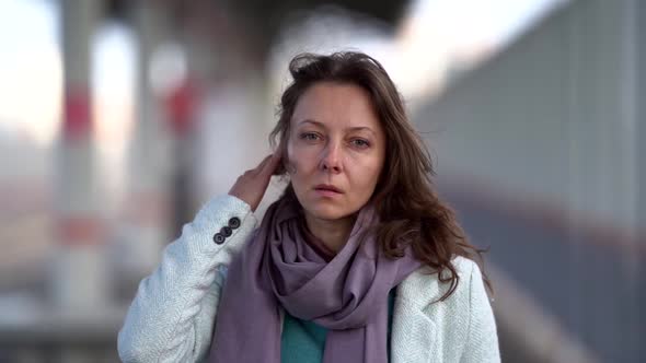 Sad Woman Is Walking Alone at Windy Autumn Day, Looking at Camera Sorrowfully, Medium Portrait alt