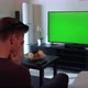 A Man Watches a TV with a Green Screen in a Cozy Living Room and Then Acts Upset and Disappointed - VideoHive Item for Sale
