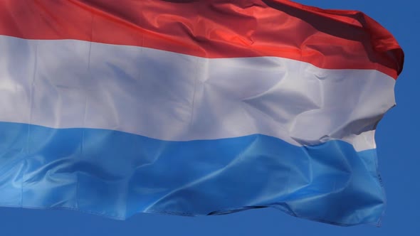 The national luxembourg flag waving in the wind. alt