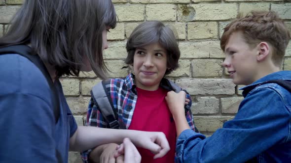 Portrait of Scared Bullied Boy Fighting with Aggressive Offenders at Wall. Brunette Caucasian alt