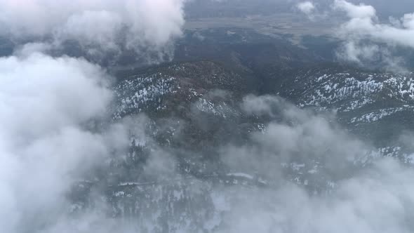 Aerial  Winter Wonderland Mountain Forest Under Fresh White Snow Under Clouds alt