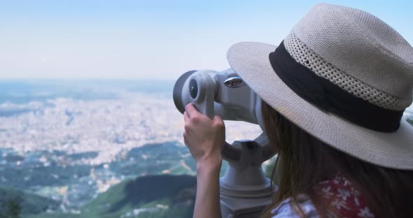 Unrecognizable Woman Traveler Looking Through Viewing Binoculars at Summer City alt