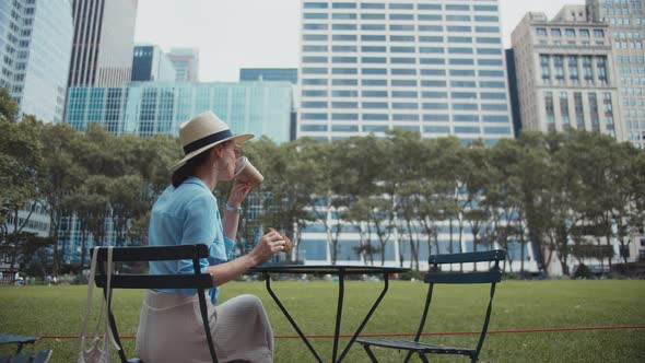 Young girl having breakfast in a park alt