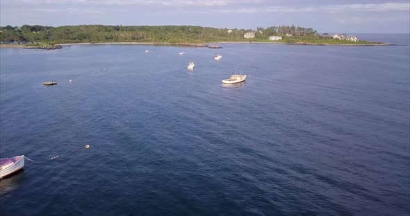Aerial shot flying over commercial fishing and lobster boats in the blue Atlantic waters off the Mai alt