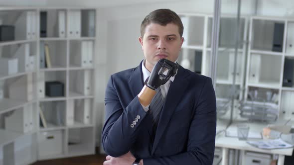 Businessman with Prosthetic Hand Thinking in the Office alt