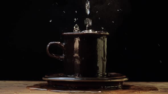 Pouring Water Into An Overflowing Cup - Slow Motion alt
