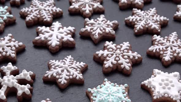 Side View of Rotating Gingerbread Cookies Snowflakes on Slate Table