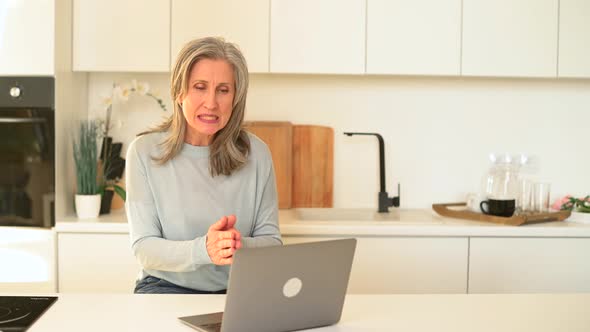 Goodlooking Senior Mature Woman is Using Laptop for Video Connection