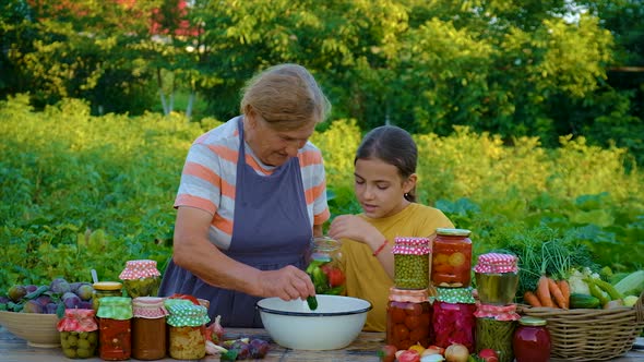 Women with Jar Preserved Vegetables for the Winter Mother and Daughter alt