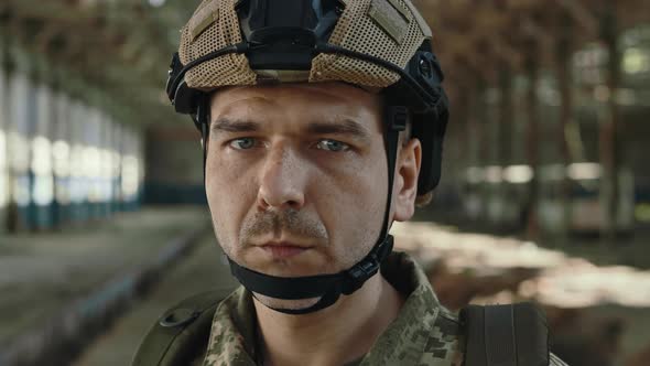 Portrait of Soldier in Uniform Posing on Abandoned Factory alt