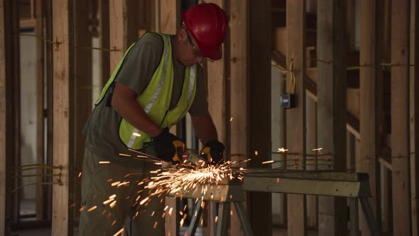 Construction worker grinding metal and making sparks, slow motion