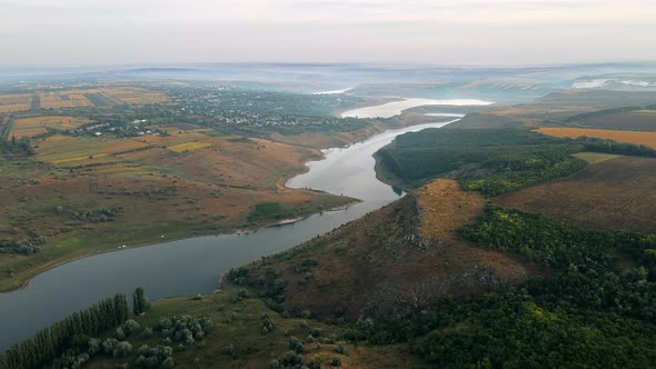 Aerial drone view of the Duruitoarea natural reservation in Moldova. River and fog in the air, hills alt