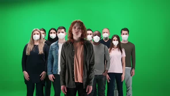 Crowd of People of Different Races and Ages Stands on a Green Background Young Guy Without a Mask alt