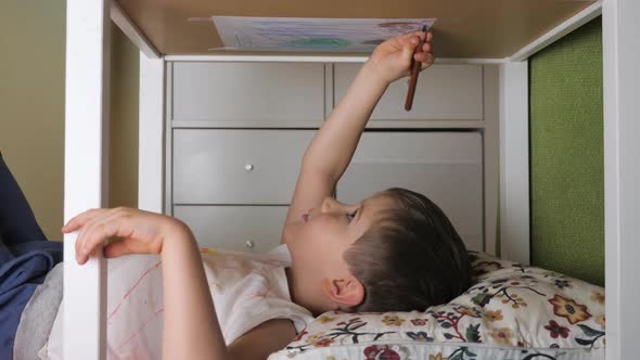 Boy Painting Upside Down. Leisure Activity at Home, Indoor. Preschooler Drawing Lying Under the