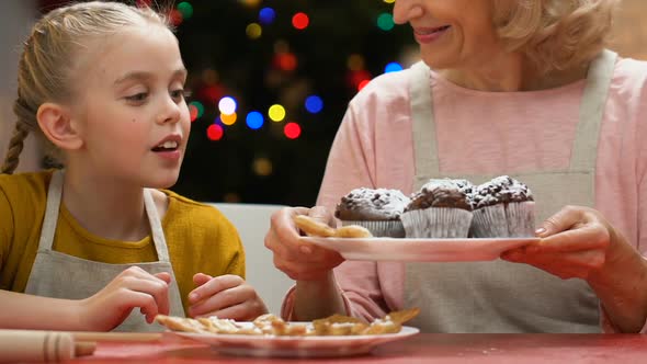 Girl Blowing Sugar Powder From Cupcakes, Laughing With Granny, Fun Together alt