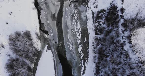 Long Narrow Road Over Frozen River Through Winter Forest Mountains - Aerial Drone Shot, Reveal alt